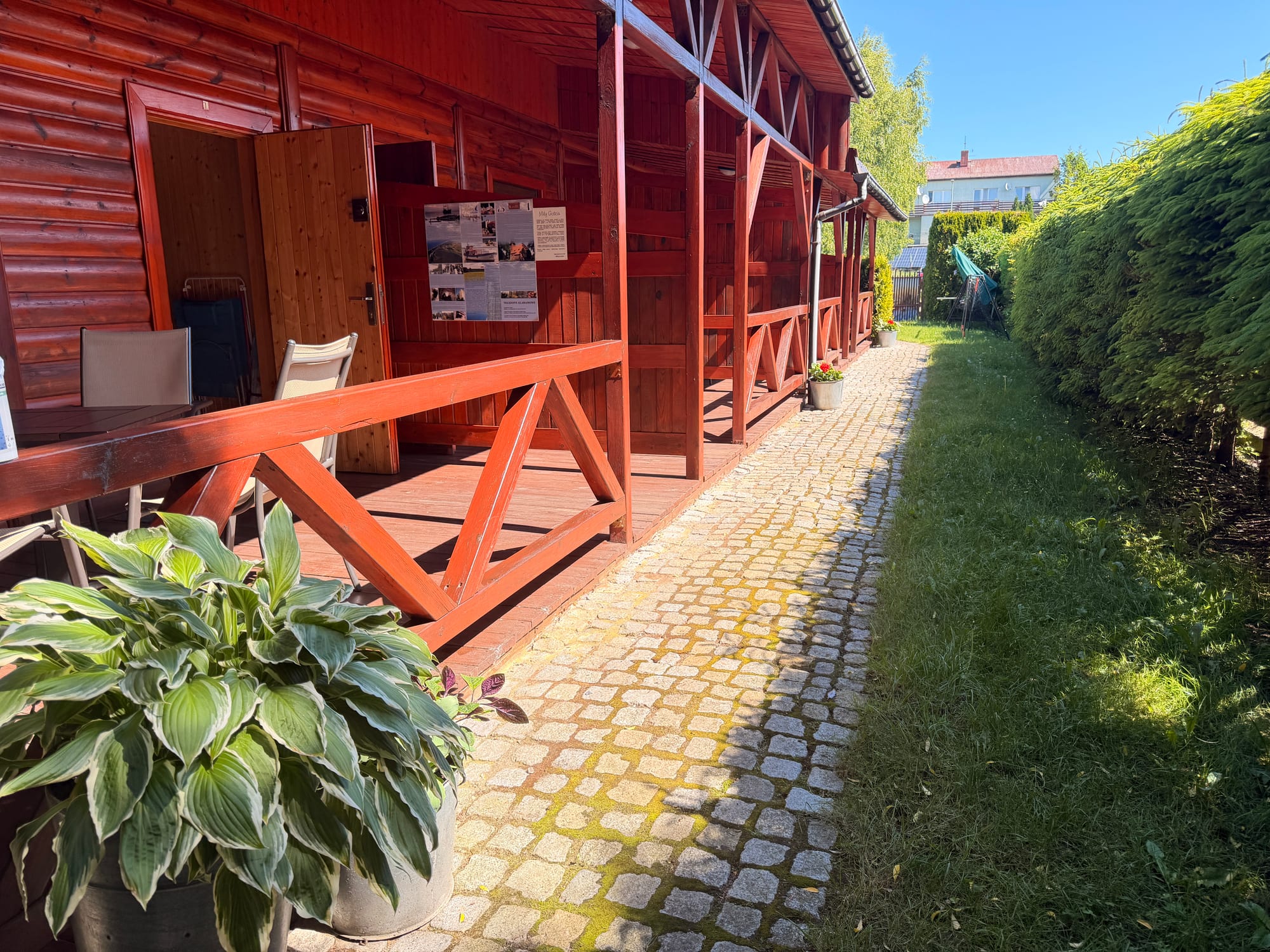 Zadaszony taras wejściowy Apartamentu nr 1 z krzesłami i stolikiem.