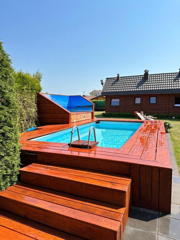 Okrągła balia jacuzzi w wiklinowym wzorze na tarasie.